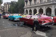 Two 1959 Ford Thunderbirds and between them a 1952 Chevrolet Bel Air convertible, along Parque Central in Old Havana, Cuba.