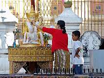 Yangon, Myanmar, 2006 - Worshipers at the Shwedagon Paya pour water over one of the small Buddha statues.