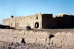 An old crumbling fortress near Herat. The building is, like the wall around it, made of mud brick.