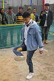 Playing “Thepi”, keeping a feathered ball as long as possible in the air by kicking.