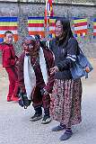 A masked “clown”, carrying a portable music player, posing with a woman after spiritual dances.