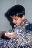 A son polishes a Papier-mâché box.