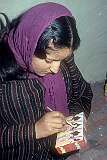 A  daughter painting a Papier-mâché box.