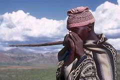 Matsieng, Lesotho, 1971 - A herd boy playing the “lesiba”, a home-made instrument.
