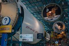 Alongside the huge Saturn V rocket,with the emblems of Apollo 11, the first moon landing on 20 July 1969, and the next  Apollo 12 mission, four months later.