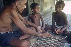 Oluvilei, Milne Bay, Papua New Guinea, 1988 - Playing drafts on Kiriwina Island, in the Trobriand Islands.