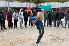 Tawang, Arunachal Pradesh, India, 2023 - Playing “Behgor”, lifting a large boulder and throwing it over his shoulder, at the Tawang Festival.
